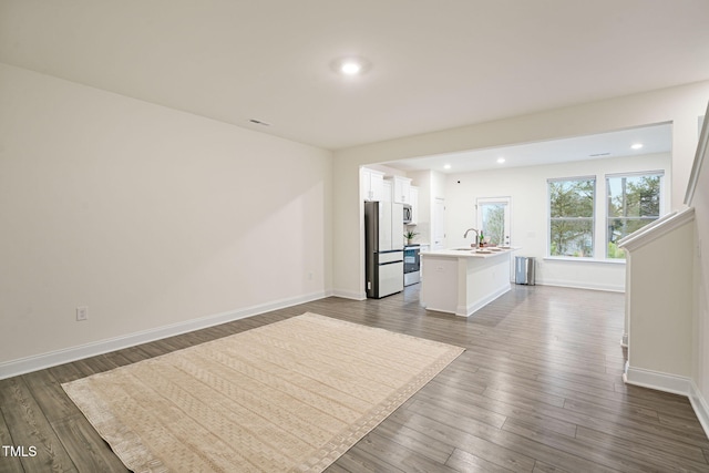 131 Wildflower Cir, Clayton, NC 27520 - unfurnished living room featuring a sink, recessed lighting, dark wood-type flooring, and baseboards