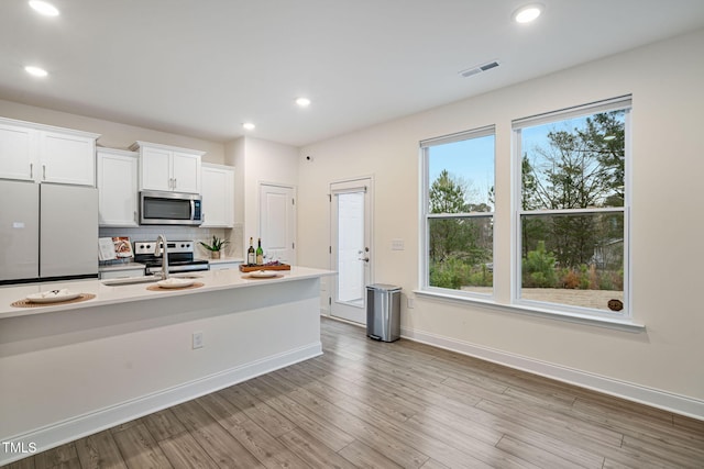 131 Wildflower Cir, Clayton, NC 27520 - kitchen featuring appliances with stainless steel finishes, white cabinets, a sink, light countertops, and backsplash