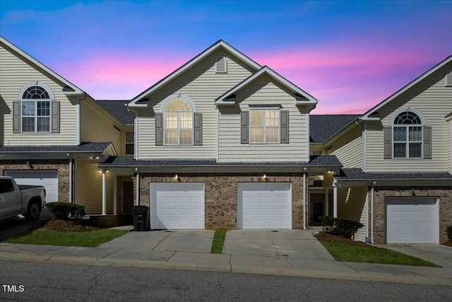 traditional-style home with brick siding, driveway, and an attached garage