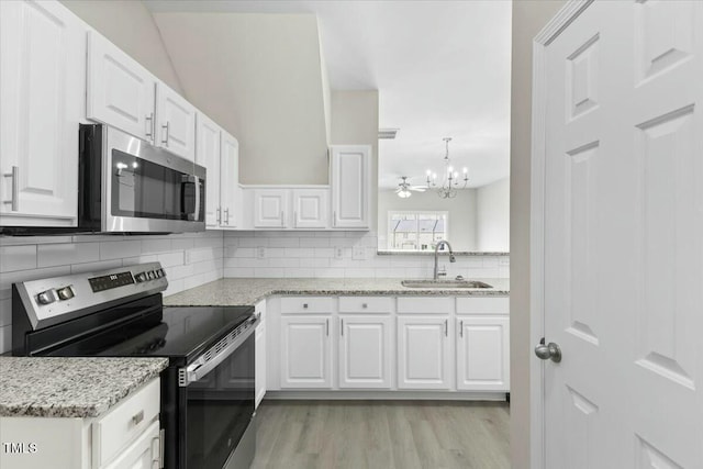 kitchen with decorative backsplash, appliances with stainless steel finishes, light wood-type flooring, white cabinetry, and a sink