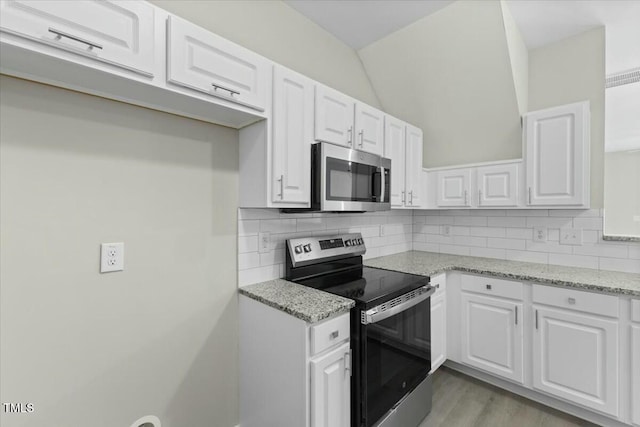 kitchen featuring appliances with stainless steel finishes, backsplash, and white cabinetry