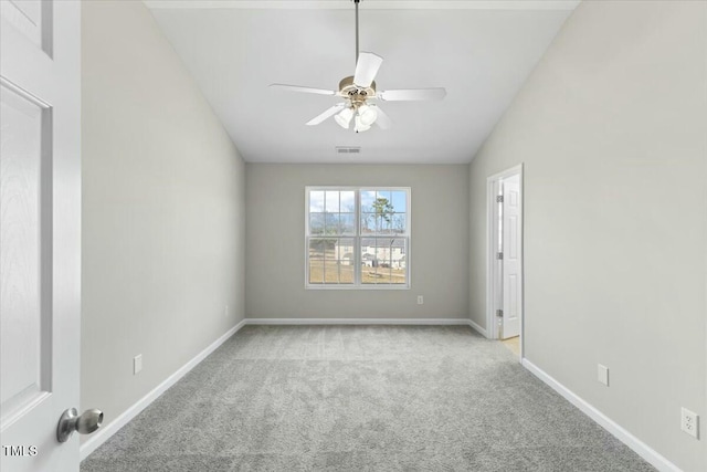 carpeted empty room featuring ceiling fan, vaulted ceiling, visible vents, and baseboards