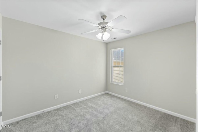 carpeted empty room featuring a ceiling fan and baseboards