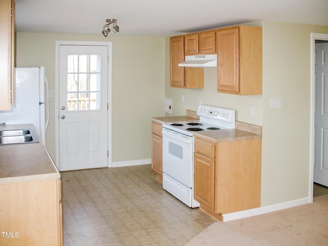 kitchen with white appliances, under cabinet range hood, light countertops, and a sink