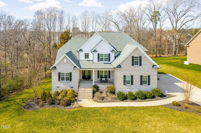 traditional home featuring crawl space, brick siding, covered porch, and a front lawn