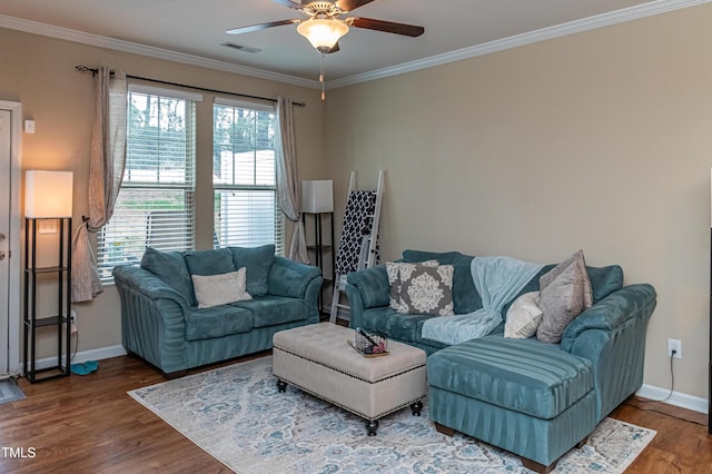 living area featuring a ceiling fan, wood finished floors, visible vents, baseboards, and crown molding