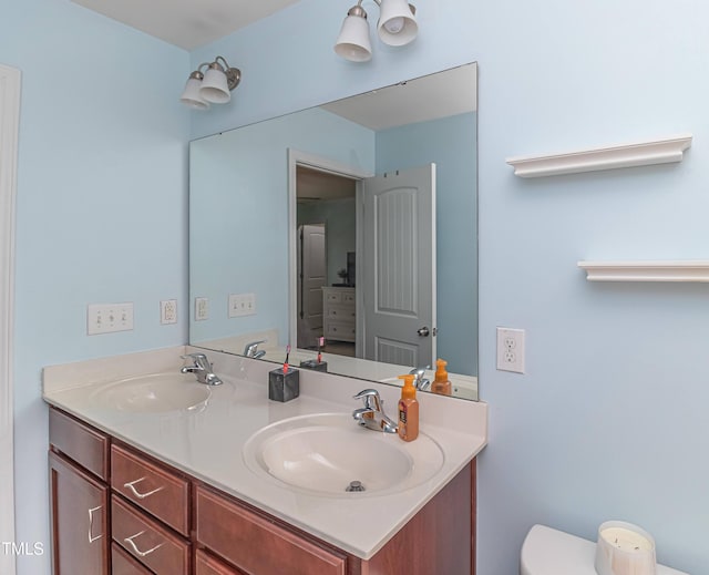 bathroom featuring a sink, toilet, and double vanity