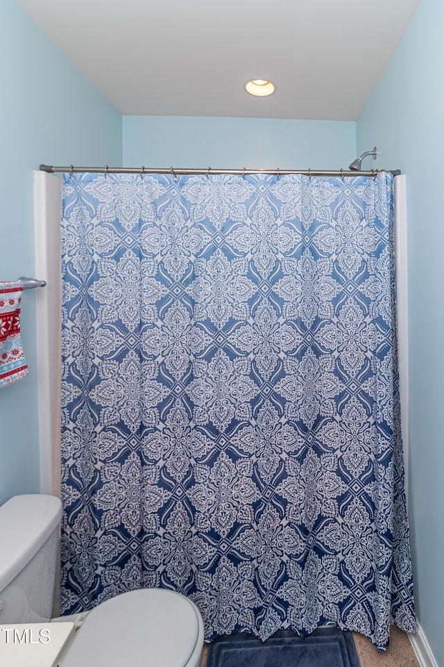 bathroom featuring toilet and a shower with curtain