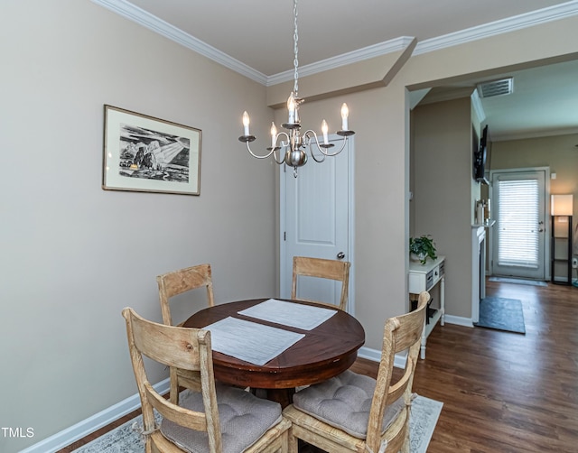 dining room featuring wood finished floors, visible vents, baseboards, ornamental molding, and a notable chandelier