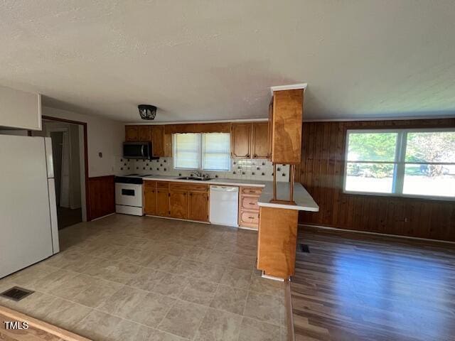 167 Chic Ennis Rd, Coats, NC 27521 - kitchen with a sink, brown cabinetry, white appliances, and plenty of natural light