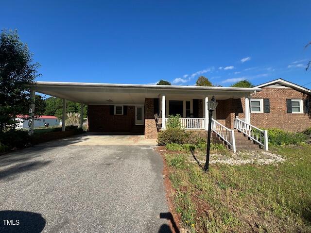 167 Chic Ennis Rd, Coats, NC 27521 - view of front of home featuring covered porch, brick siding, driveway, and an attached carport