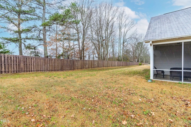 view of yard with a sunroom and a fenced backyard