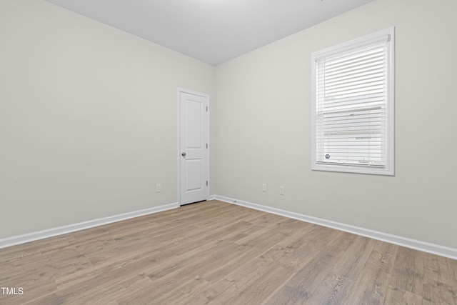 spare room featuring light wood-style flooring and baseboards