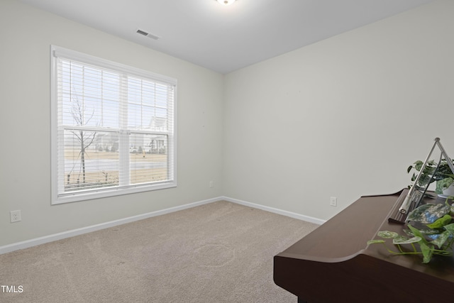 carpeted spare room with baseboards and visible vents