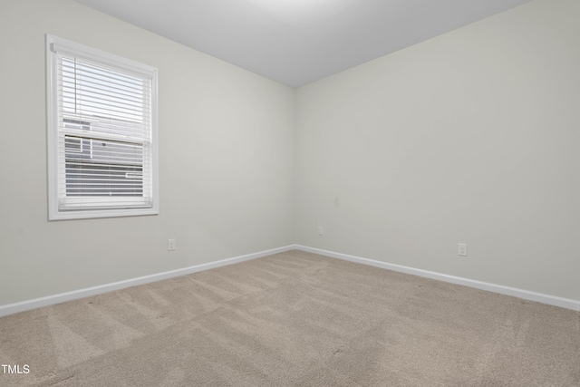 empty room featuring carpet floors and baseboards