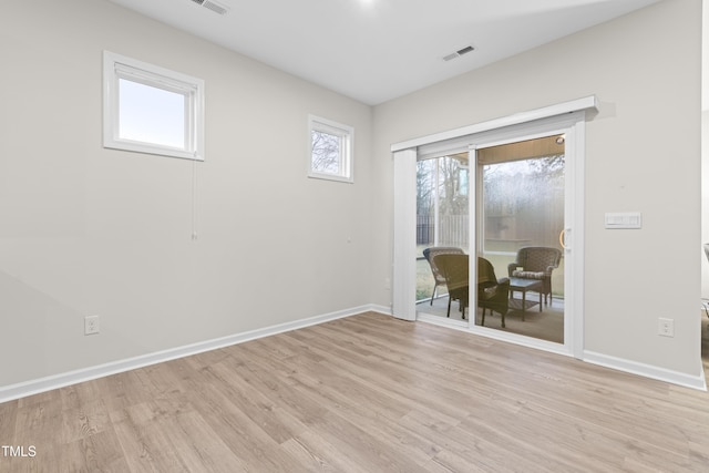 empty room with baseboards, visible vents, and light wood-style floors