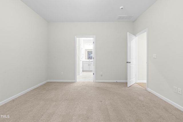 unfurnished room with light carpet, visible vents, and baseboards