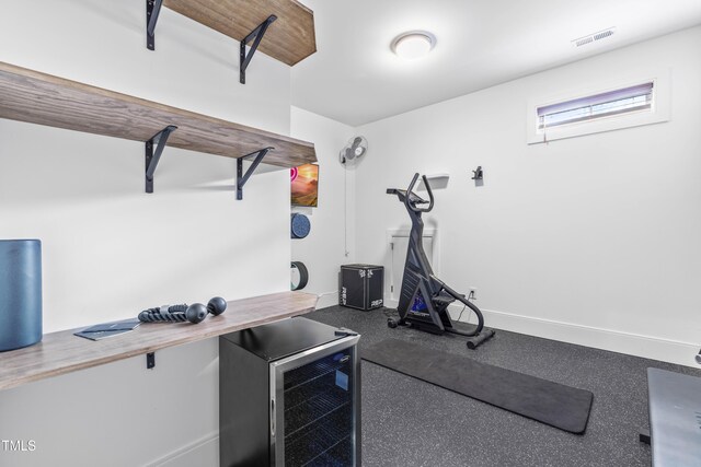 workout area featuring wine cooler, visible vents, and baseboards