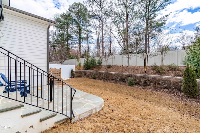 view of yard featuring stairs and a fenced backyard