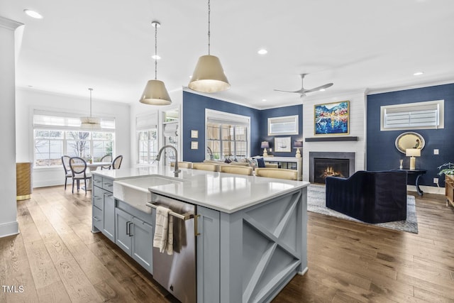 kitchen with stainless steel dishwasher, dark wood finished floors, gray cabinets, and light countertops