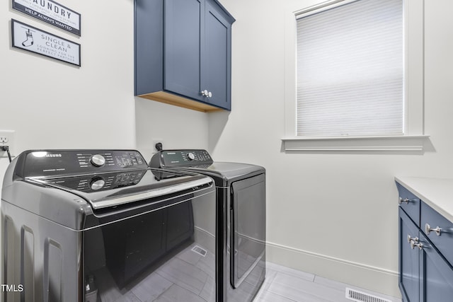 clothes washing area featuring washer and dryer, baseboards, cabinet space, and visible vents