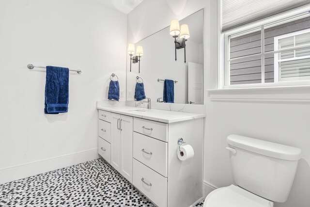 bathroom featuring vanity, tile patterned floors, toilet, and baseboards