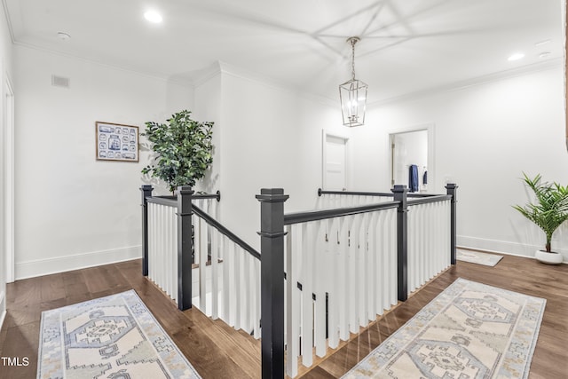 corridor featuring an upstairs landing, crown molding, baseboards, and wood finished floors