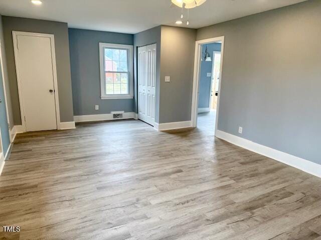 empty room featuring recessed lighting, wood finished floors, and baseboards