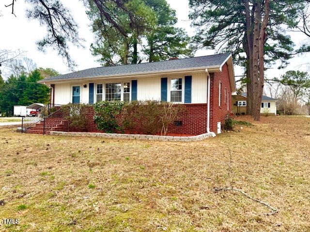 ranch-style home featuring brick siding and a front yard