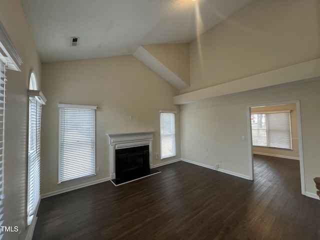 unfurnished living room featuring visible vents, baseboards, a fireplace with raised hearth, and dark wood finished floors