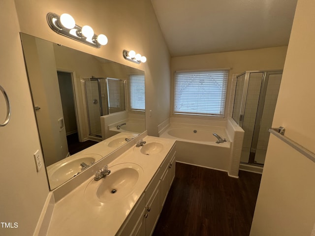 full bathroom featuring lofted ceiling, a sink, and a garden tub