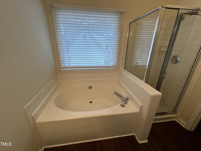 full bathroom with a garden tub, a shower stall, and wood finished floors