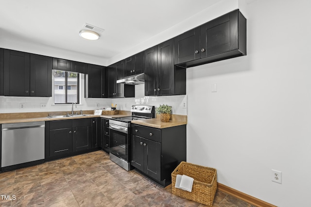 kitchen with dark cabinets, stainless steel appliances, a sink, visible vents, and tasteful backsplash