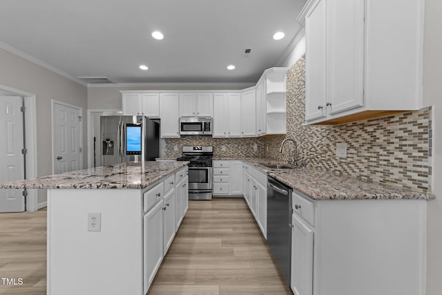 10133 Bessborough Dr, Raleigh, NC 27617 - kitchen featuring crown molding, a sink, a kitchen island, stainless steel appliances, and white cabinets