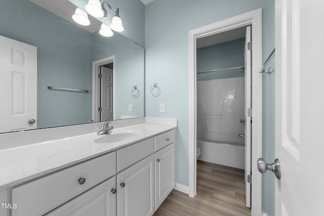 10133 Bessborough Dr, Raleigh, NC 27617 - bathroom with tub / shower combination, baseboards, toilet, wood finished floors, and vanity
