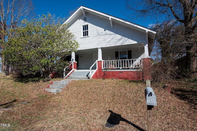 view of front of home featuring covered porch and a front lawn