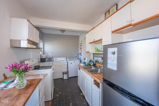 kitchen with range with electric cooktop, a sink, white cabinetry, freestanding refrigerator, and washing machine and clothes dryer