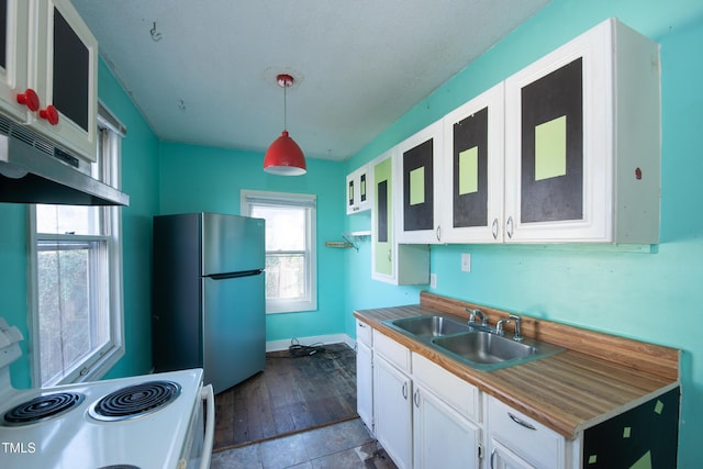 kitchen with white electric range oven, white cabinets, freestanding refrigerator, under cabinet range hood, and a sink