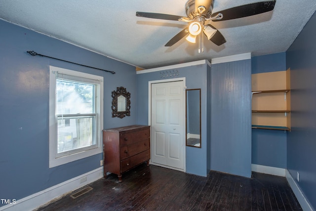 unfurnished bedroom with visible vents, ceiling fan, a textured ceiling, wood finished floors, and baseboards