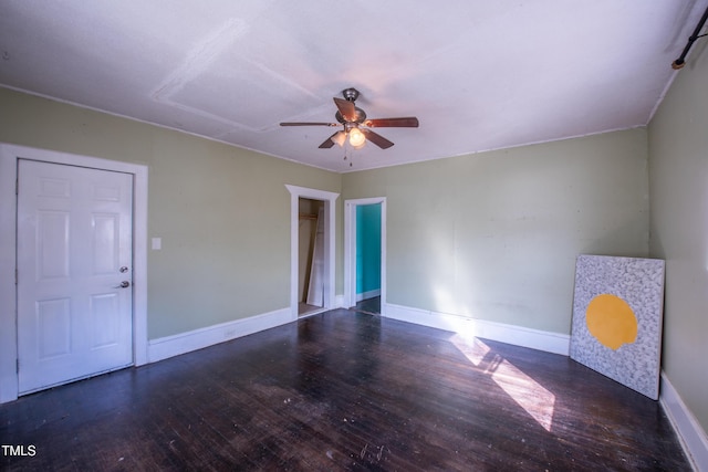 empty room with a ceiling fan, baseboards, and wood finished floors