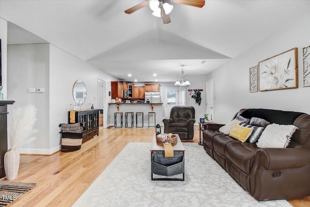 living area with light wood finished floors, lofted ceiling, recessed lighting, baseboards, and ceiling fan with notable chandelier