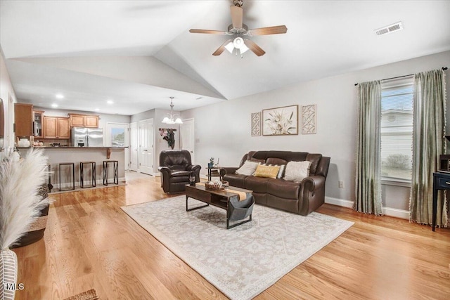 living room featuring visible vents, a ceiling fan, vaulted ceiling, light wood-type flooring, and baseboards