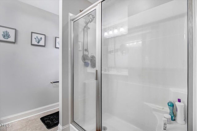 bathroom featuring tile patterned flooring, baseboards, and a shower stall