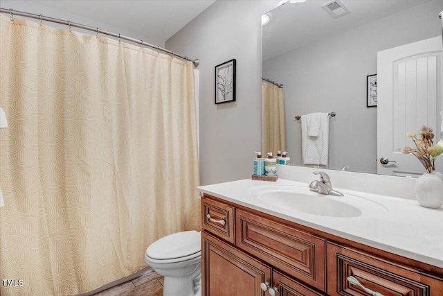 bathroom featuring toilet, tile patterned flooring, vanity, and visible vents