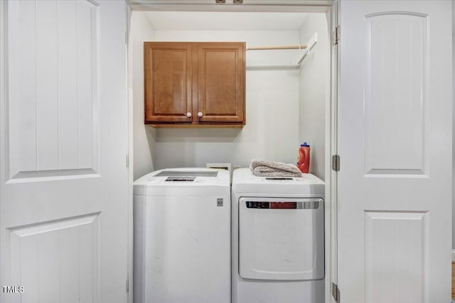 laundry room with washing machine and dryer and cabinet space