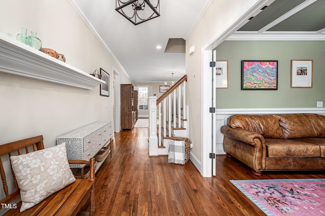 entrance foyer with baseboards, ornamental molding, wood finished floors, stairs, and a notable chandelier