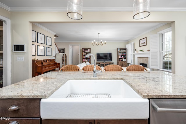 kitchen featuring open floor plan, a fireplace, a sink, and crown molding