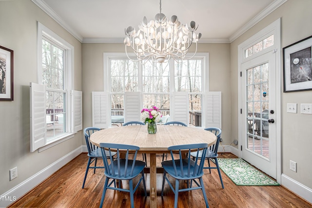 dining area with wood finished floors, a wealth of natural light, and crown molding