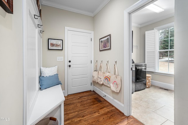 mudroom featuring a healthy amount of sunlight, crown molding, visible vents, and baseboards