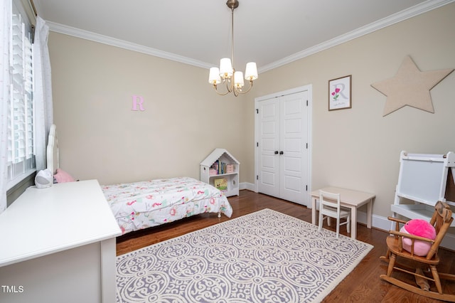 bedroom featuring a notable chandelier, wood finished floors, baseboards, a closet, and crown molding